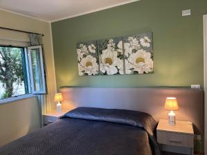 a bedroom with a bed with two lamps and a window at A Casuzza in Pollina