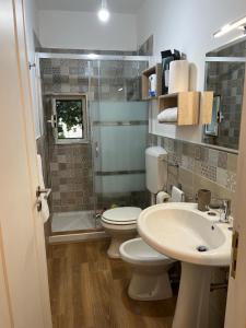 a bathroom with a toilet and a sink and a shower at A Casuzza in Pollina