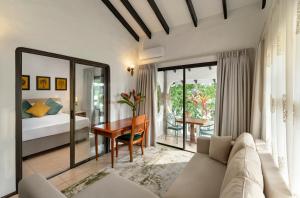 a living room with a couch and a bedroom at Eden's Holiday Villas in Mahe