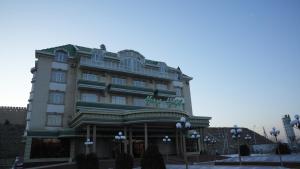 a large building with a sign on top of it at Hepci Hotel Istaravshan in Ŭroteppa