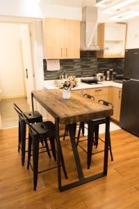 a kitchen with a wooden table with chairs and a refrigerator at Relaxing Mountain View 2BR Fast WiFi and PS5 in Manila