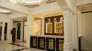 a lobby with clocks on display in a building at Hepci Hotel Istaravshan in Ŭroteppa