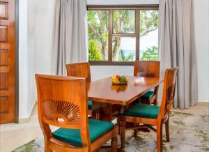 a dining room with a wooden table and chairs at Eden's Holiday Villas in Mahe