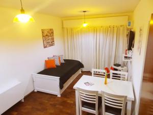 a small room with a bed and a table and chairs at Departamento Temporario Céntrico Mendoza in Mendoza