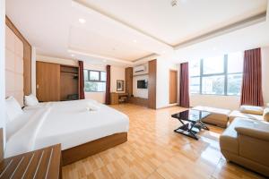 a hotel room with a large bed and a couch at Dolphin Bay Hotel Nha Trang in Nha Trang