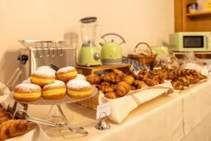 ein Tisch mit Donuts und anderem Gebäck darauf in der Unterkunft Hotel Royal in Menaggio