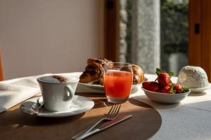ein Tisch mit Frühstücksspeisen, einer Tasse Kaffee und Erdbeeren in der Unterkunft Hotel Royal in Menaggio