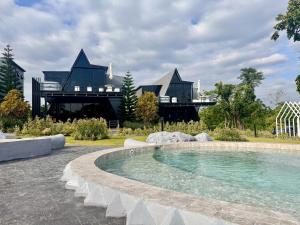 a house with a swimming pool in front of a building at ฟูจิจันท์ fujijun cafe&resort in Ban Na Khieo