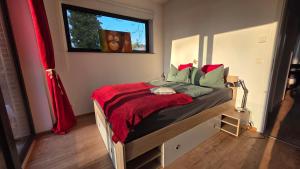 a bedroom with a bed with a red blanket at Seeblick, ganze Wohnung in Königs Wusterhausen
