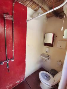 a bathroom with a red door and a toilet at Posada Las Piedras in Tilcara +9 photos