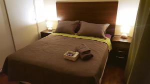 a bedroom with a bed with two towels and two lamps at Departamento Temporario Céntrico Mendoza in Mendoza