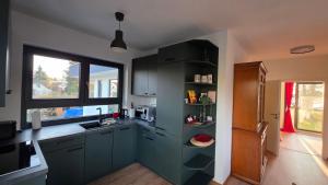 a kitchen with blue cabinets and a window at Seeblick, ganze Wohnung in Königs Wusterhausen