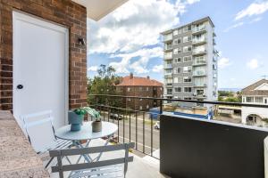 a balcony with a table and a view of a building at Medusa Bondi in Sydney