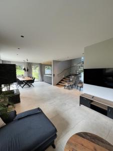 a large living room with a couch and a tv at Villa Chalet Schlossalm bis 9 Personen in Bad Hofgastein