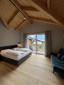 a bedroom with a large bed and a couch at Villa Chalet Schlossalm bis 9 Personen in Bad Hofgastein +34 photos