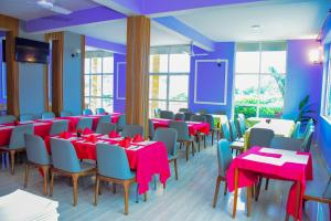 a room with tables and chairs with red tablecloths at The Residence Hotel Dodoma in Dodoma