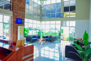 a large room with couches and tables and windows at The Residence Hotel Dodoma in Dodoma