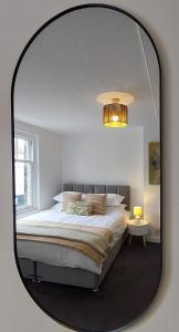 a bedroom with a large bed and a mirror at 1A Central Bedford Apartment in Bedford