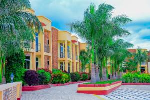 a row of buildings with palm trees in a courtyard at The Residence Hotel Dodoma in Dodoma