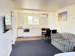 a living room with a couch and a table at Abode Motel in Palmerston North