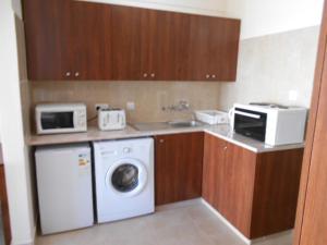 a kitchen with a washing machine and a microwave at Ayia Napa Apartment in Ayia Napa