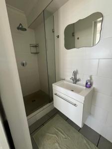 a bathroom with a sink and a shower with a mirror at 87 Marine Drive in Struisbaai +24 photos
