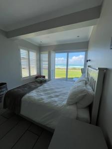 a bedroom with a large bed and a large window at 87 Marine Drive in Struisbaai