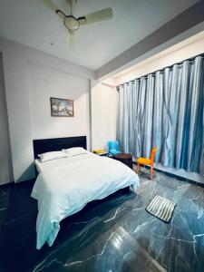 a bedroom with a bed and a table and a chair at Hotel Dream Crown in Bhopal