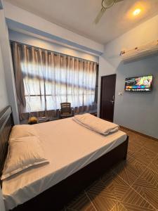 a bedroom with a large bed and a window at Hotel Dream Crown in Bhopal