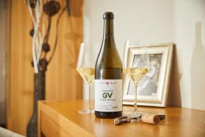 a bottle of wine and two glasses on a table at Villa Tolnay Vendégház in Gyulakeszi +10 photos