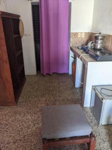 a kitchen with a purple curtain and a table at Sam in Mahajanga