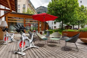 eine Terrasse mit Fahrrädern und einem Tisch mit Sonnenschirm in der Unterkunft Hotel Schweizerhof Lenzerheide in Lenzerheide + 75 Fotos