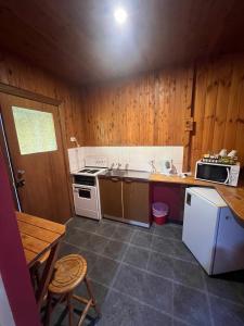 a kitchen with a stove and a sink and a microwave at Bunkhouse Motel Cooma in Cooma