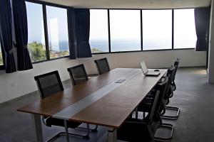 a conference room with a large wooden table and chairs at The Siren Resort Nusa Penida - Ocean View Villas in Nusa Penida +101 photos