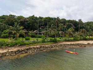 a person in a kayak in the water near a beach at Tolani Resort Koh Kood in Ko Kood +88 photos
