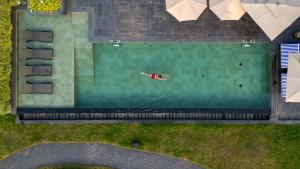an overhead view of a person swimming in a pool at Amaaranth Goa in Varca