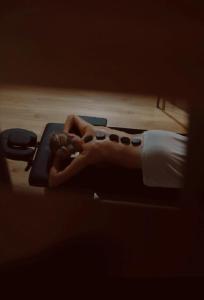 a person laying on a bed holding a video game controller at oto.domki in Rokiciny Podhalanskie