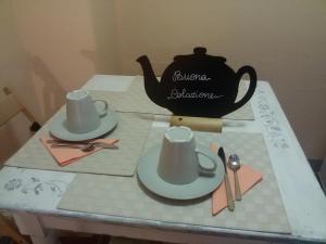 a table with two hats and a tea kettle at Affittacamere Gir di Mura in Montecatini Terme