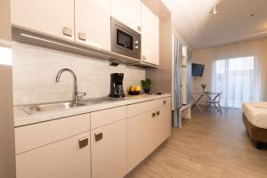 a kitchen with white cabinets and a sink at east Apart in Erlangen