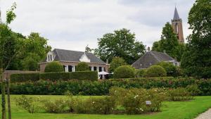 a large house with a garden and a church at B&B Het Gasthuys in Amerongen +56 photos