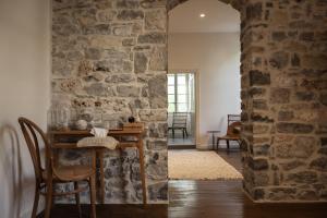 a room with a table and a stone wall at Couvent de la Salette & Spa in Millau