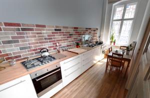 a kitchen with a brick wall and a stove top oven at Havana in Wrocław