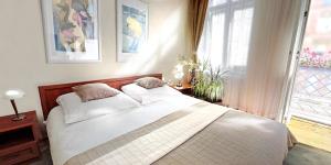 1 dormitorio con 1 cama con 2 almohadas y ventana en Havana en Breslavia