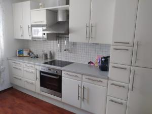 a kitchen with white cabinets and a stove top oven at Villa Siegrid in Kremsmünster +4 photos