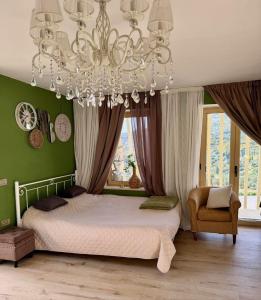 a bedroom with a bed and a chandelier at Katerina's House in Volímai