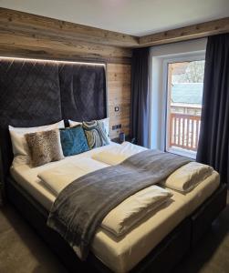 a large bed in a room with a window at Sieglhub Chalets - Appartements - Hotel in Flachau
