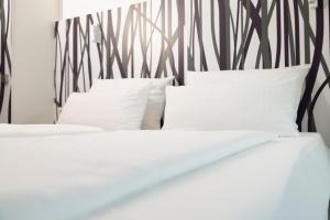 two beds with white pillows and a black and white headboard at east Apart in Erlangen