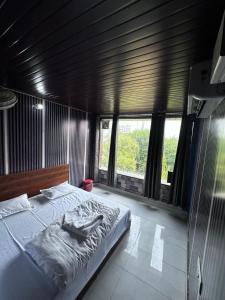 a bedroom with a large bed in a room with windows at Taj hotel in Hisār