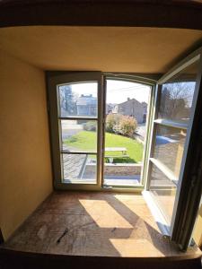 an empty room with two windows and a view of a bench at Lu Stâve in Stoumont +21 photos