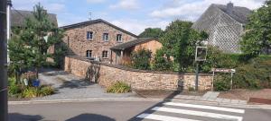 an old brick building next to a street with a crosswalk at Lu Stâve in Stoumont